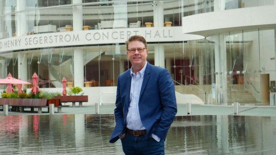 Mike Buley in a navy blazer standing in front of Segerstrom Concert Hall in Costa Mesa.